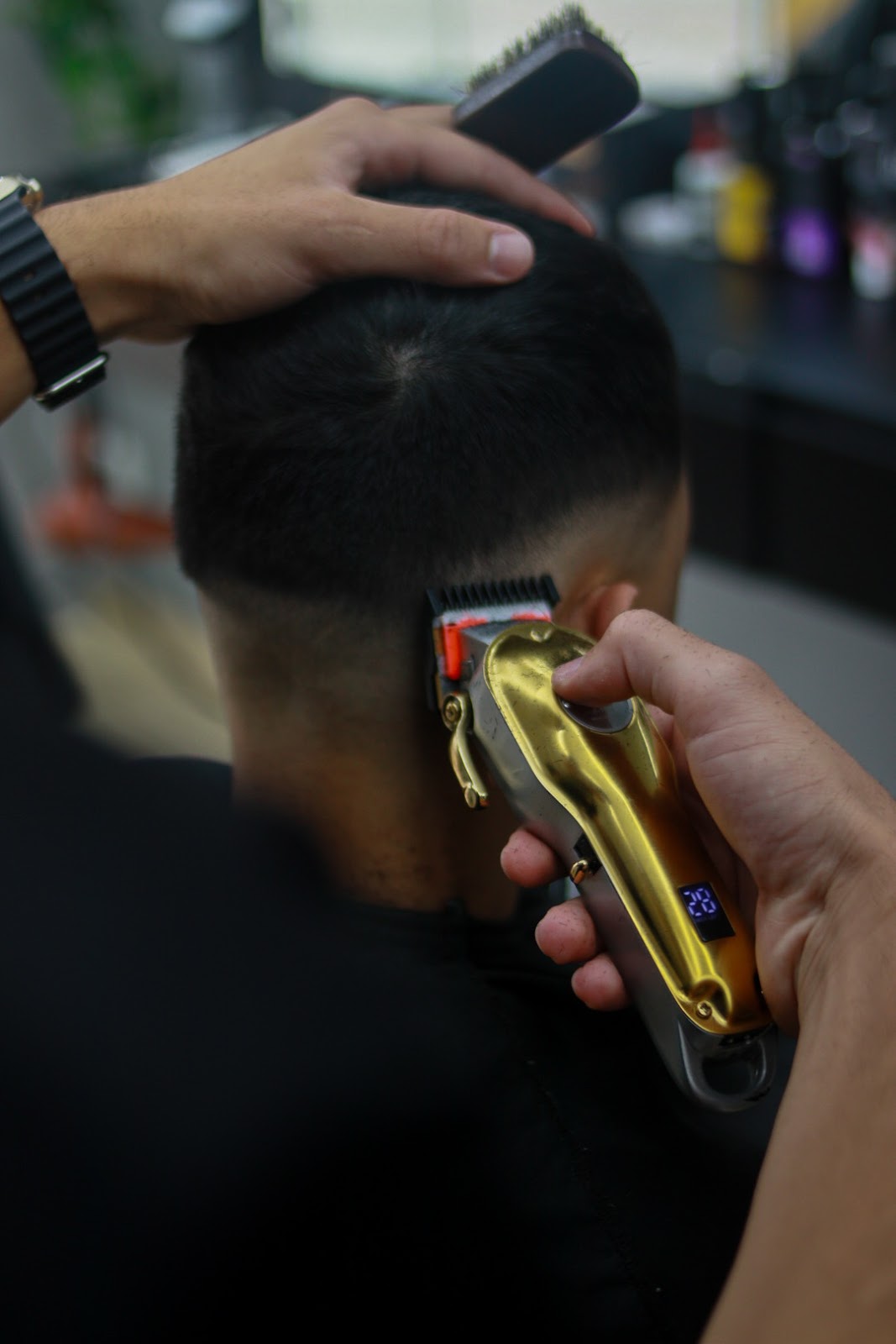 Detalhe do corte de cabelo com máquina dourada na Barbearia Navalha Nobre